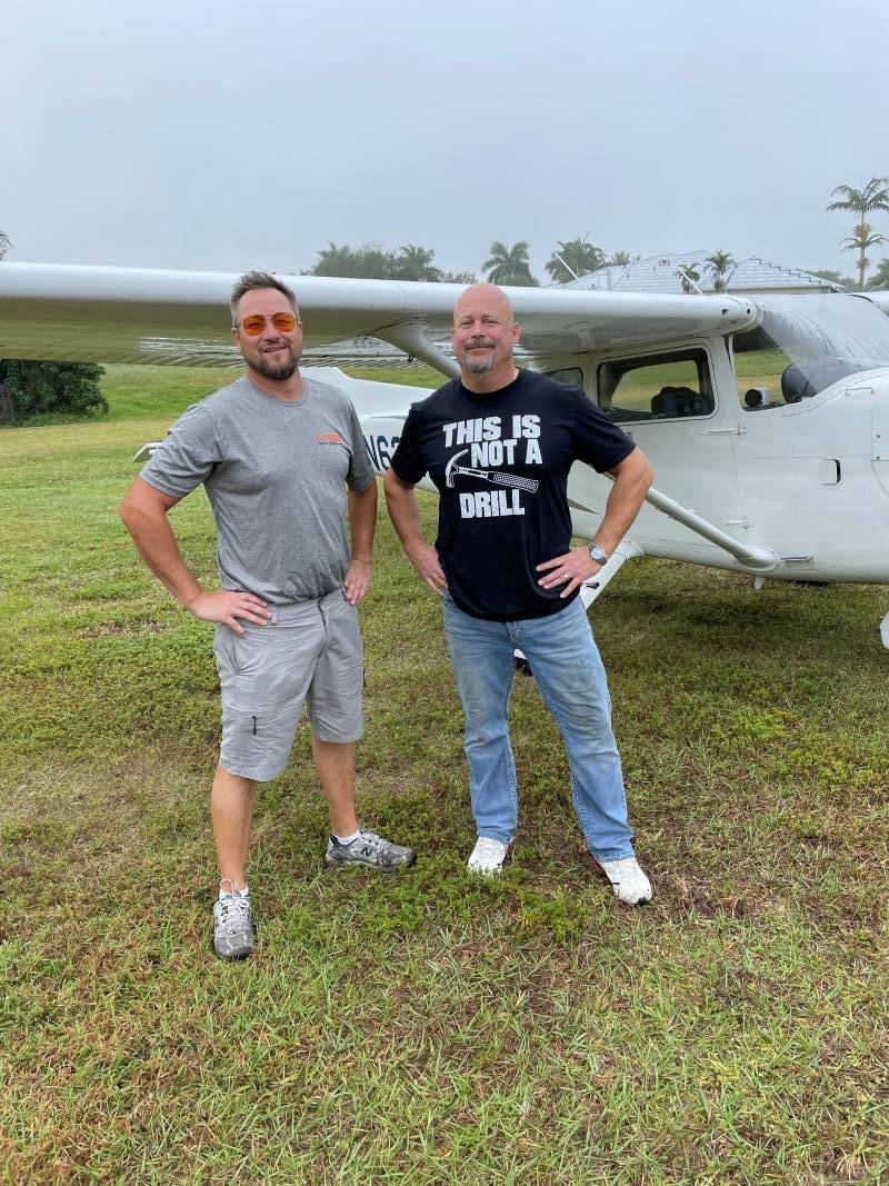 two guys in front of a plane